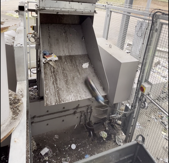 Photographie d'un équipement industriel extrayant une bouteille de protoxyde d'azote d'un flux de déchets